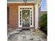 Close-up of the front door with decorative wreath, surrounded by sidelights and brick facade at 1382 Murrays Loch Nw Pl, Kennesaw, GA 30152