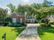 Charming brick home with a well-manicured lawn, mature trees, and a circular driveway at 1382 Murrays Loch Nw Pl, Kennesaw, GA 30152