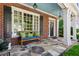 Inviting front porch with stone flooring, comfortable bench seating, and classic architectural details at 1382 Murrays Loch Nw Pl, Kennesaw, GA 30152