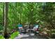 Seating area with table and chairs surrounded by a peaceful wooded landscape at 1382 Murrays Loch Nw Pl, Kennesaw, GA 30152