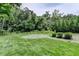 Manicured backyard featuring a gravel section, grassy lawn, and mature trees at 4237 Rickenbacker Ne Way, Atlanta, GA 30342