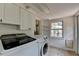 Functional laundry room with white cabinets, modern washer and dryer, and a window at 4237 Rickenbacker Ne Way, Atlanta, GA 30342