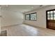 Spacious living room featuring light wood flooring, a rustic wood door, and black trimmed windows at 4237 Rickenbacker Ne Way, Atlanta, GA 30342