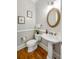 Elegant half bathroom with a pedestal sink, ornate mirror, and classic design at 125 Franklin Pl, Atlanta, GA 30342