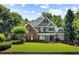 Beautiful two-story home with lush green lawn, manicured landscaping, and a classic brick and gray exterior at 125 Franklin Pl, Atlanta, GA 30342