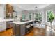 Modern kitchen features white cabinetry, stainless steel appliances, a center island, and a dining area at 125 Franklin Pl, Atlanta, GA 30342