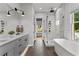 Modern bathroom with double vanity, soaking tub, walk-in shower, and natural light at 185 Central Ave, Fayetteville, GA 30214