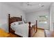 Bright bedroom features a wooden bed frame, ceiling fan, and sunny window views at 185 Central Ave, Fayetteville, GA 30214