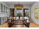 Charming dining room features a wood table, bench seating, modern light fixture and backyard views at 185 Central Ave, Fayetteville, GA 30214