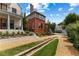 Charming home featuring red brick, arched window, lush greenery, and gravel driveway at 185 Central Ave, Fayetteville, GA 30214