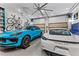 Spacious garage with two sports cars, overhead lighting, and wall-mounted storage racks at 185 Central Ave, Fayetteville, GA 30214