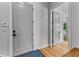 Bright hallway with hardwood floors leading to interior doors and a patterned welcome mat at 185 Central Ave, Fayetteville, GA 30214