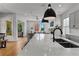 Bright, open kitchen featuring white countertops, modern lighting, a sink, and a view of the living area at 185 Central Ave, Fayetteville, GA 30214