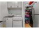 A well-appointed laundry room with washer, dryer, sink, storage, and organized shelving at 185 Central Ave, Fayetteville, GA 30214