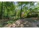 A stone patio leads to a large grassy yard, framed by trees and a wooden fence at 220 Hollyridge Dr, Roswell, GA 30076