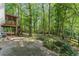 Private backyard with a screened porch, patio area, and mature trees at 220 Hollyridge Dr, Roswell, GA 30076