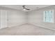 Bright bedroom with neutral carpet, ceiling fan, and large window at 220 Hollyridge Dr, Roswell, GA 30076