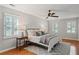 Bright bedroom featuring wood floors, a ceiling fan, and windows with plantation shutters at 220 Hollyridge Dr, Roswell, GA 30076