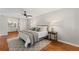 Comfortable bedroom with wood floors, ceiling fan, neutral walls, and large windows at 220 Hollyridge Dr, Roswell, GA 30076