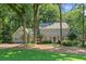 Charming two-story home with a stone facade and attached garage nestled among mature trees at 220 Hollyridge Dr, Roswell, GA 30076