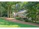 View of a charming two-story home with green lawn and mature trees at 220 Hollyridge Dr, Roswell, GA 30076