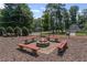 Fire pit surrounded by benches in a wood-chip area at 220 Hollyridge Dr, Roswell, GA 30076