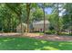 Charming two-story home with stone accents, nestled among mature trees, and a well-manicured lawn at 220 Hollyridge Dr, Roswell, GA 30076