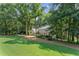 Manicured lawn with mature trees in front of the two-story house at 220 Hollyridge Dr, Roswell, GA 30076