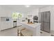 Bright kitchen with stainless steel appliances, white cabinetry, marble backsplash, and center island at 220 Hollyridge Dr, Roswell, GA 30076