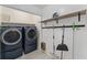 Functional laundry room with modern washer and dryer, storage shelves, and utility organization at 220 Hollyridge Dr, Roswell, GA 30076
