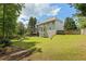 Spacious backyard featuring lush green grass, garden beds, and a charming two-story home at 2873 Hilton Nw Cir, Kennesaw, GA 30152