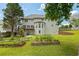 Lush backyard with garden beds, a spacious lawn, and a charming two-story home with a deck at 2873 Hilton Nw Cir, Kennesaw, GA 30152