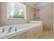 Bathroom with a large soaking tub, walk-in shower, and beige tile at 2873 Hilton Nw Cir, Kennesaw, GA 30152