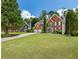 Lovely exterior view of a brick house with a manicured lawn and a long driveway leading to an attached two-car garage at 2873 Hilton Nw Cir, Kennesaw, GA 30152