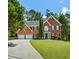 Beautiful two-story brick home with a well-manicured lawn and a long driveway leading to a two-car garage at 2873 Hilton Nw Cir, Kennesaw, GA 30152