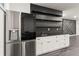 Wet bar featuring stainless steel refrigerator, white cabinetry, and floating shelves that add a modern touch at 2922 Parkridge Ne Dr, Brookhaven, GA 30319