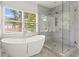 Bright bathroom features a freestanding tub next to a large window, and a glass enclosed shower with marble surround at 2922 Parkridge Ne Dr, Brookhaven, GA 30319
