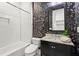 Stylish bathroom with subway tile, black vanity, and elegant wallpaper at 2922 Parkridge Ne Dr, Brookhaven, GA 30319