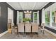 Elegant dining room featuring a dark accent wall, modern chandelier, large windows, and seating for six at 2922 Parkridge Ne Dr, Brookhaven, GA 30319