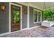 Inviting front porch with a wooden front door, a swing, and a brick floor for a relaxing outdoor space at 2922 Parkridge Ne Dr, Brookhaven, GA 30319