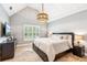 Bright bedroom featuring vaulted ceilings, neutral tones, natural light, and an eye-catching pendant light fixture at 3088 Hidden Falls Dr, Buford, GA 30519