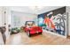 Playful bedroom with unique wall art, light hardwood floors, and bright natural light from two windows at 3088 Hidden Falls Dr, Buford, GA 30519