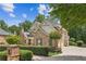 Well-manicured front yard and exterior of a two-story brick home with multiple gables and a driveway at 3088 Hidden Falls Dr, Buford, GA 30519