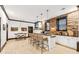 Living room with bar seating area, stacked stone accent wall, hardwood floors, and modern lighting at 3088 Hidden Falls Dr, Buford, GA 30519
