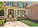 Charming covered front porch with stone accents, seating area, and decorative details, inviting guests inside at 3088 Hidden Falls Dr, Buford, GA 30519