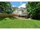 Backyard featuring a large deck, mature trees, and green lawn at 4544 Cavallon Nw Way, Acworth, GA 30101