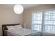 Cozy bedroom featuring a queen bed, large window with shutters, and stylish lighting at 37 La Rue Nw Pl, Atlanta, GA 30327
