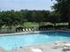 A picturesque community pool surrounded by mature trees, sun loungers, tables, and a large manicured lawn at 37 La Rue Nw Pl, Atlanta, GA 30327