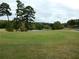 Beautifully maintained community golf course and green with mature trees and water feature at 37 La Rue Nw Pl, Atlanta, GA 30327