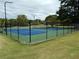 Fenced community tennis courts with vibrant blue surface offer recreational opportunities at 37 La Rue Nw Pl, Atlanta, GA 30327